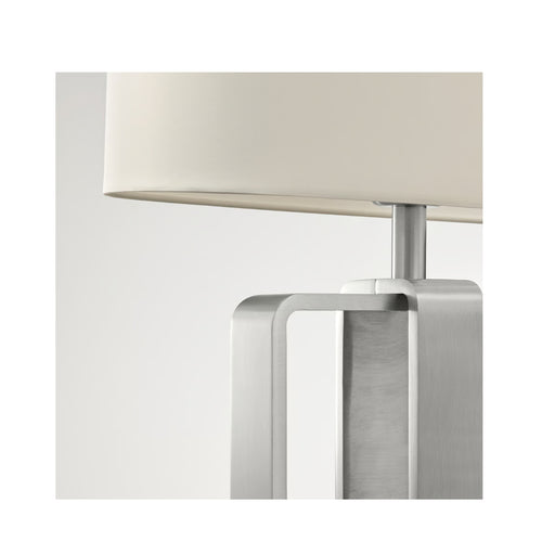 Modern table lamp with a beige shade and metallic base on a white background