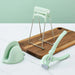 Mint green kitchen tool set on a wooden cutting board with a light green background