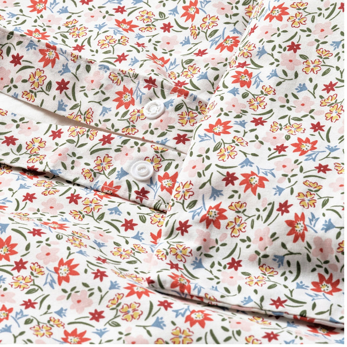 “Close-up of cotton fabric with small red, pink, and green flowers on a white background, part of duvet cover and pillowcase set.”