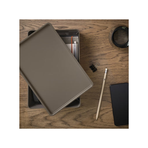 Brown leather wallet on a wooden surface with a pencil and black phone