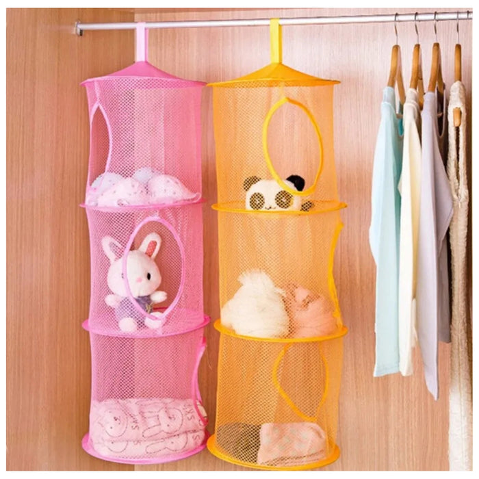 Pink and orange mesh hanging organizers with toys inside on a wooden wardrobe.