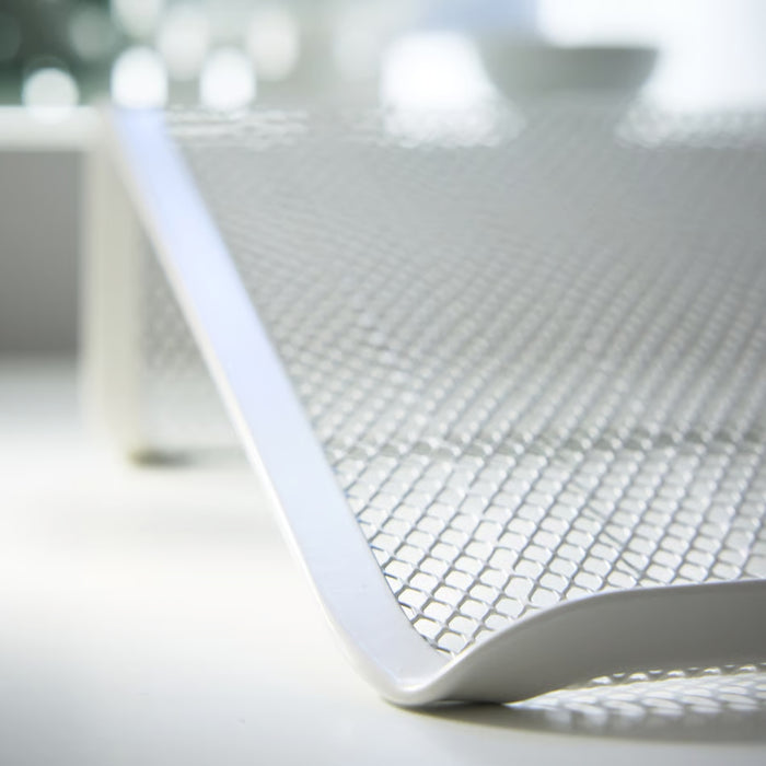 Close-up of a white mesh chair with blurred background