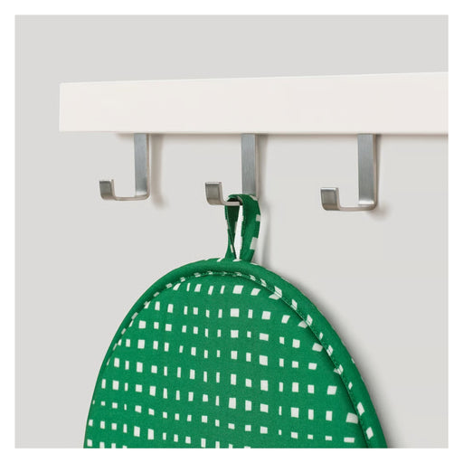 Green pot holder with white pattern hanging on a white wall-mounted hook rack.