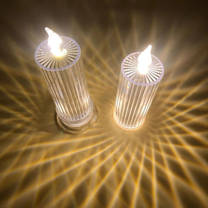 Two illuminated cylindrical candles on a textured surface with a warm glow.