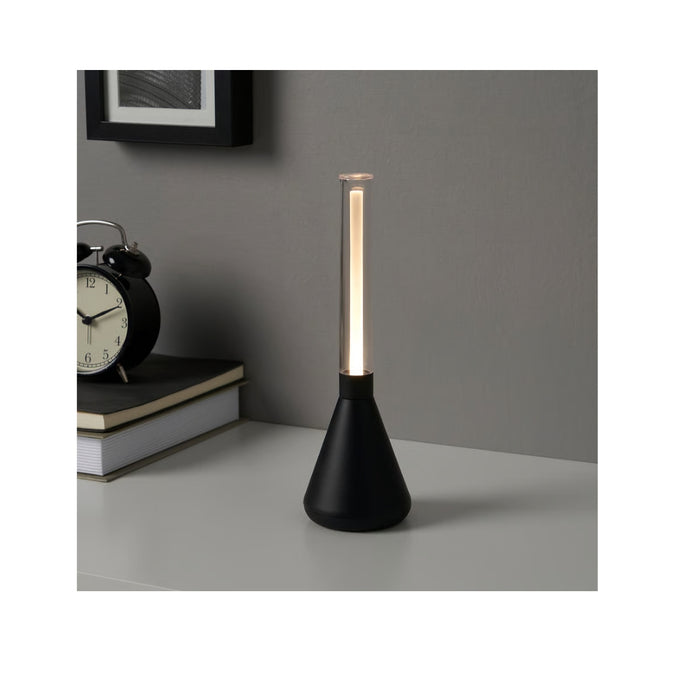  IKEA BJÖRKSPIREA black LED desk light placed next to a clock on a wooden surface