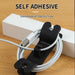 Black cable clip holding white cables with text 'Self Adhesive' and 'Environment Protection' on a wooden surface.