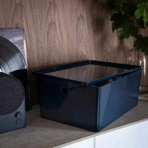 KUGGIS box styled on a countertop beside speaker and vinyl sleeve, adding sleek storage to a modern setup