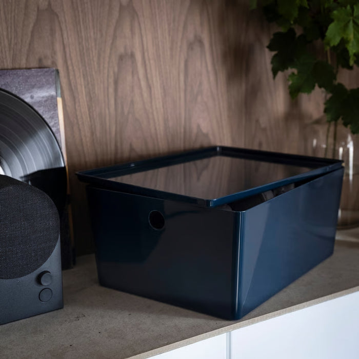 KUGGIS box styled on a countertop beside speaker and vinyl sleeve, adding sleek storage to a modern setup