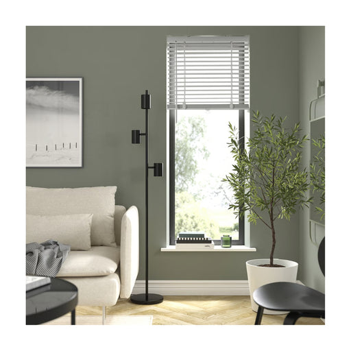 Living room with a floor lamp, sofa, and window with blinds.