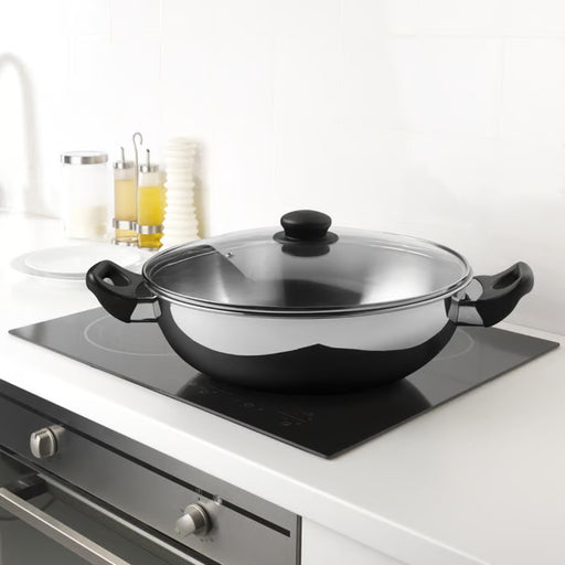 IKEA GULDSPARID Kadai wok with lid, 30 cm (12 "), placed on induction cooktop in modern kitchen setup - 00601445