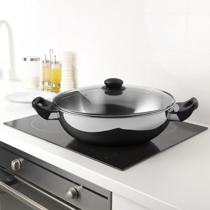IKEA GULDSPARID Kadai wok with lid, 30 cm (12 "), placed on induction cooktop in modern kitchen setup - 00601445