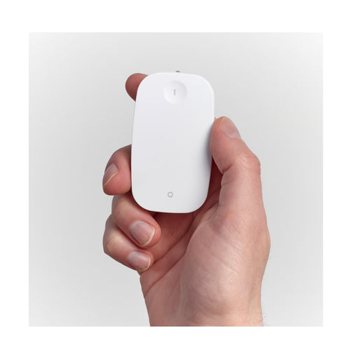 Hand holding a small white device against a light gray background