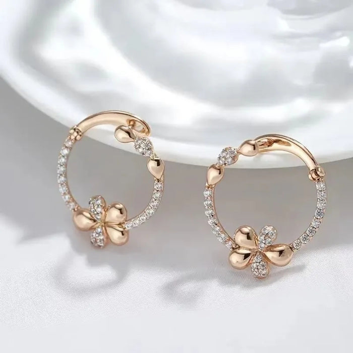 Rose gold earrings with floral designs on a white background