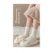 Person wearing fluffy white socks with a soft texture, sitting on a bed.