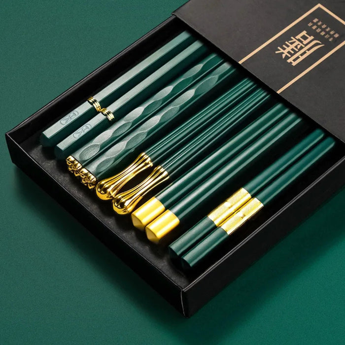 Set of green chopsticks with gold accents in a black box on a green background