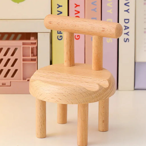 Mini chair mobile holder placed near pastel books and pink crate – functional desk accessory with clean aesthetic – 1598453326009 13953547
