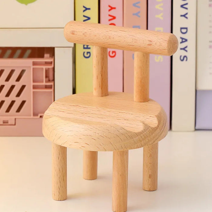 Mini chair mobile holder placed near pastel books and pink crate – functional desk accessory with clean aesthetic – 1598453326009 13953547