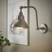 IKEA ANKARSPEL lamp lit beside framed sketch and plant, mounted on light wall for cozy accent lighting