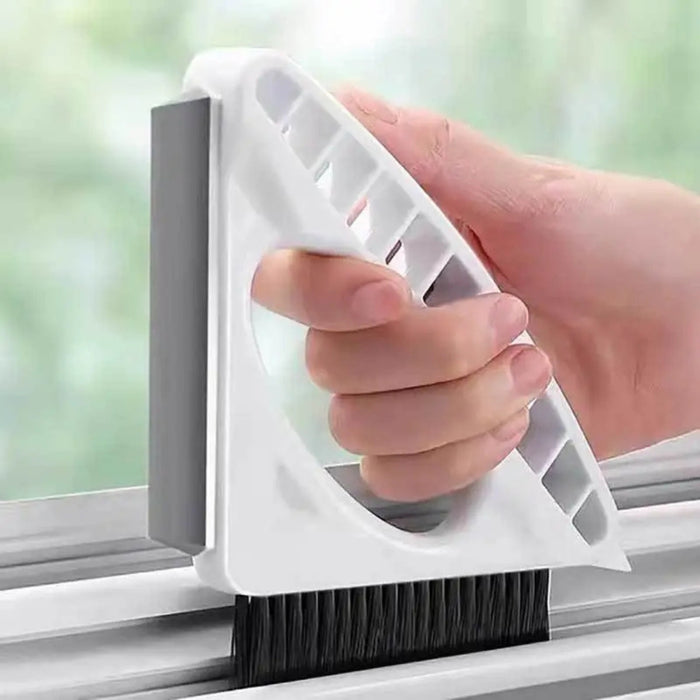 Window cleaning tool with a brush being used to clean a window