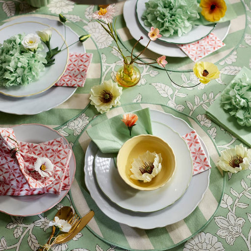  IKEA UPPLAGA plates styled on floral tablecloth with yellow bowls, gold cutlery, and artificial flowers for spring setup