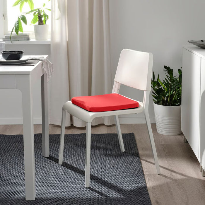 STAGGSTARR pad placed on white dining chair beside table with black bowl and striped napkin