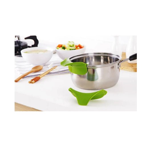 Green kitchen tool on a pot with a blurred kitchen background