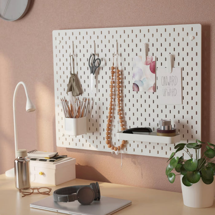 IKEA SKÅDIS 7-piece accessories set in white mounted on pegboard; includes tray, container, clips, and hooks organizing scissors, pencils, tape, and decor – ideal for creative workspace and home office storage - 80586417