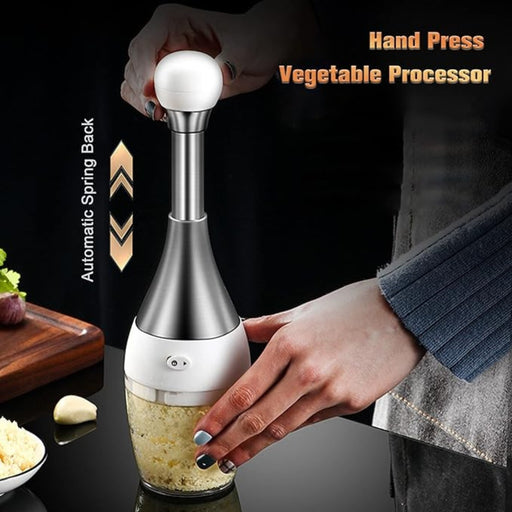 Person using the hand-press vegetable processor to quickly mince garlic cloves with an automatic spring-back mechanism.