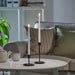 SMÅLOM taper candles lit in black holders on round coffee table beside ceramic teapot and cup, styled in cozy living room
