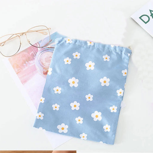 Light blue floral pouch placed on a white surface beside eyeglasses and a photo – 1598445710448 14078092