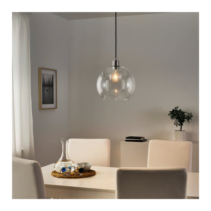 Dining room with a modern pendant light fixture, table, chairs, and decor items.
