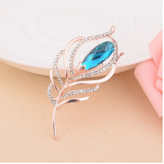 rose gold feather design with blue gemstone and rhinestone accents