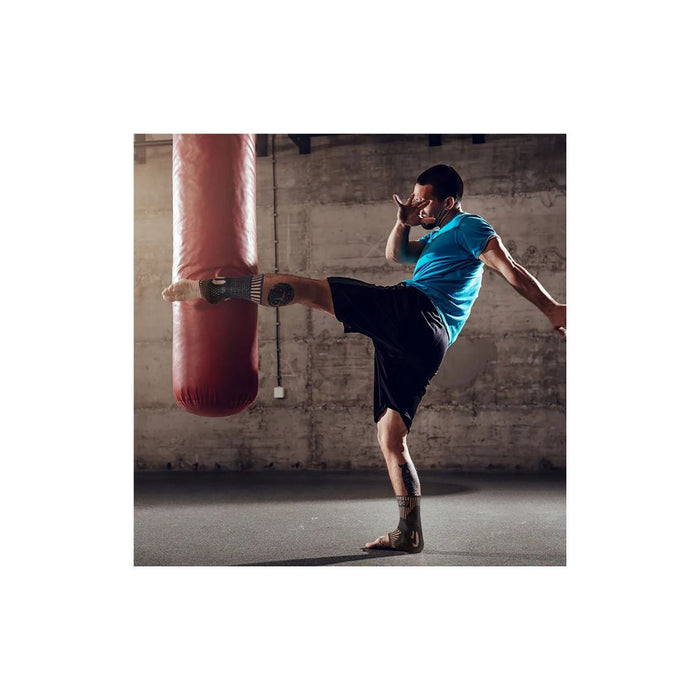 Person kicking a punching bag in a gym setting
