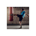 Person kicking a punching bag in a gym setting