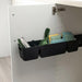 Black cabinet organizer with cleaning supplies inside a white cabinet.