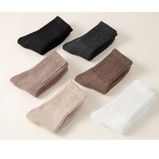 Set of six pairs of socks in black, gray, brown, beige, and white on a light background