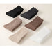 Set of six pairs of socks in black, gray, brown, beige, and white on a light background