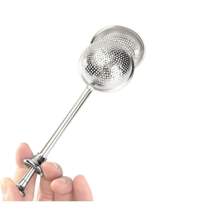 Metallic kitchen strainer held by a hand on a white background