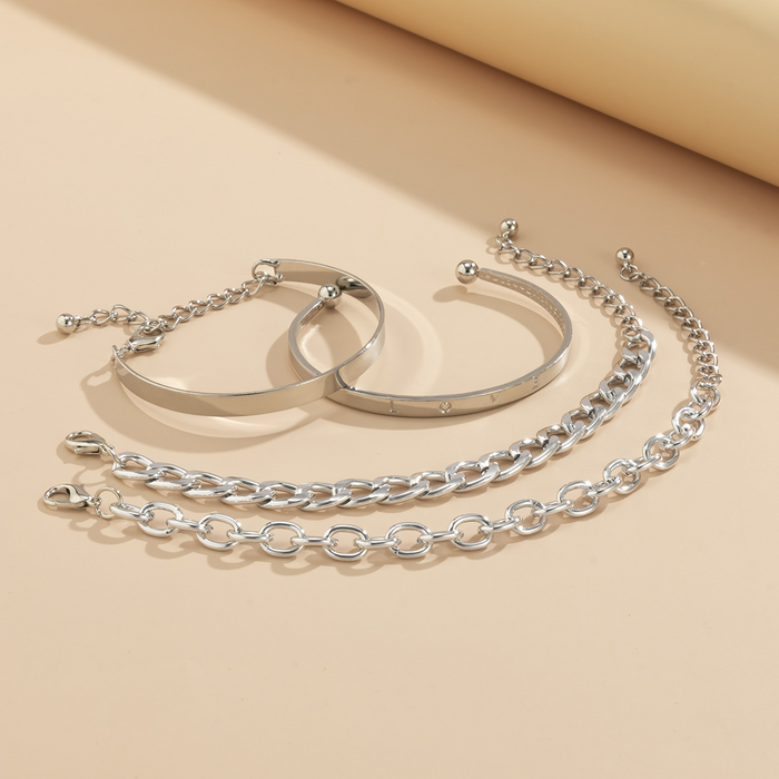 Shiny C-shaped bracelet reflecting light on a jewelry display stand