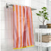 Soft cotton SLÅNHÖSTMAL towel in vibrant orange and pink, 70x140 cm