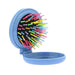 Curly hair being detangled with rainbow rounded bristle brush