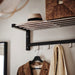 Clothing rack with coat, hat, and scarf hanging on a wall.