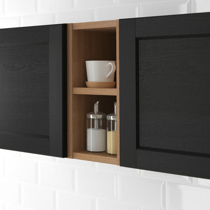 Black kitchen cabinet with a wooden interior containing a white mug and jars.