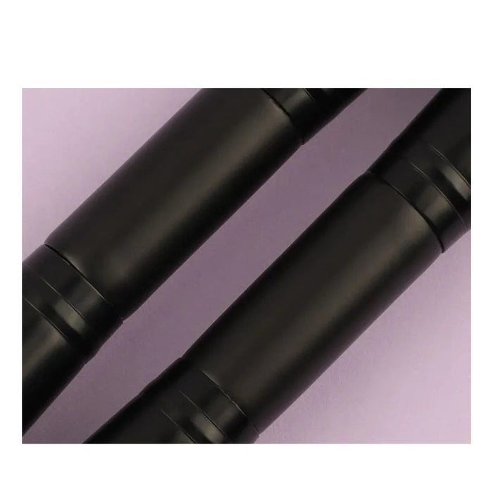 Two black cylindrical objects on a light purple background
