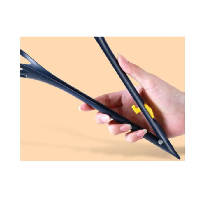 Hand holding a black stylus with a yellow button on a beige background