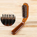 Brown hairbrush with close-up of bristles on a wooden background