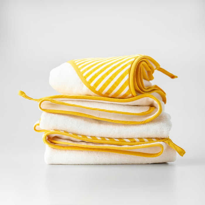 Stack of folded towels with yellow stripes on a light gray background