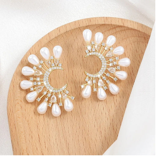 Digital Shoppy moon pearl earrings – elegant crescent earrings with radial pearl and zircon design on wooden surface

