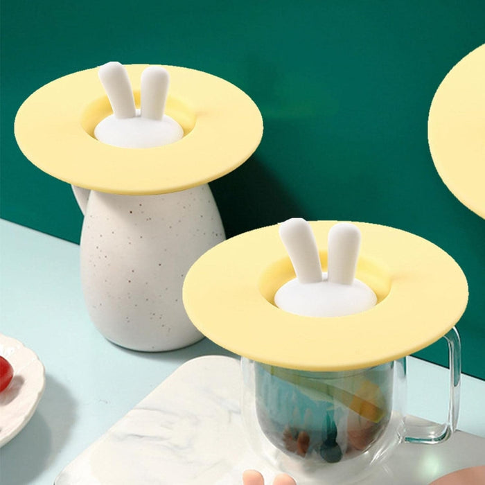 Transparent mug and speckled pitcher covered with yellow silicone lids featuring bunny ears – decorative and functional drink covers – 1598447679156 13987144