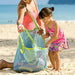 Woman and child on a beach with a mesh bag